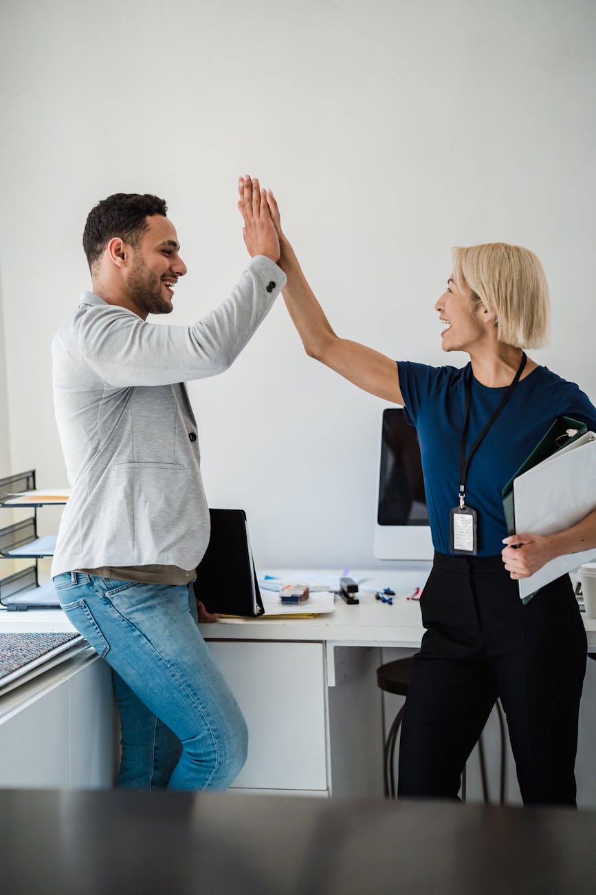 man and woman high five in office