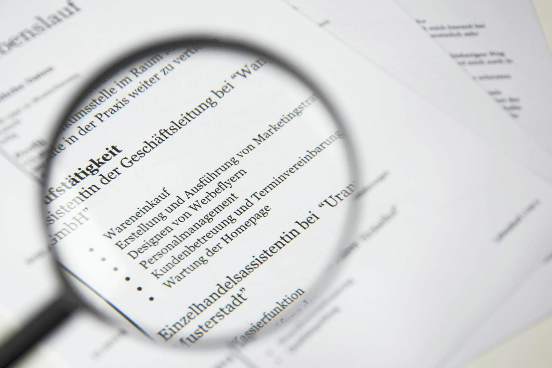magnifying glass beside white printer paper