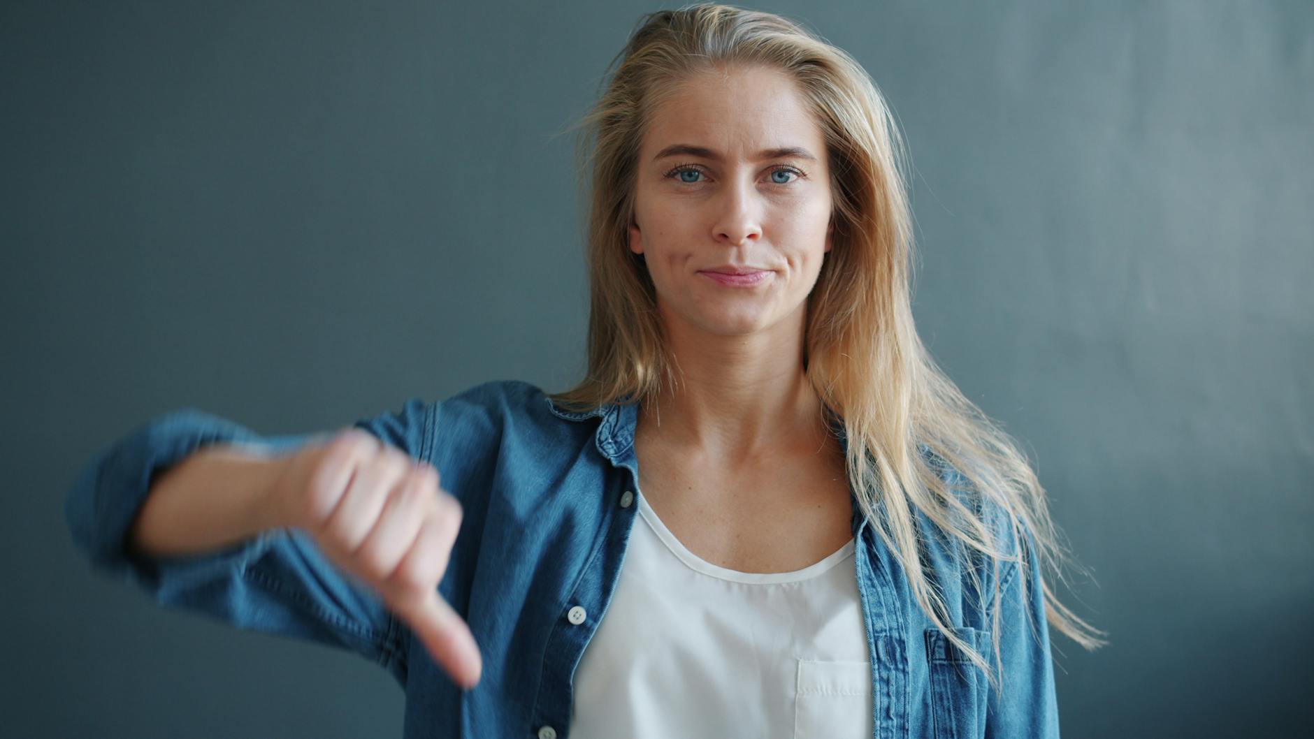 young woman showing thumbs down gesture